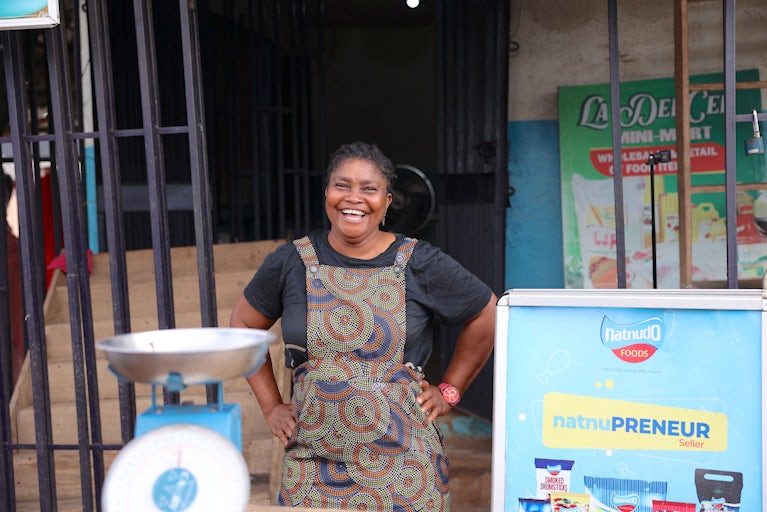 A woman stands outside her poultry shop in Edo State, Nigeria.