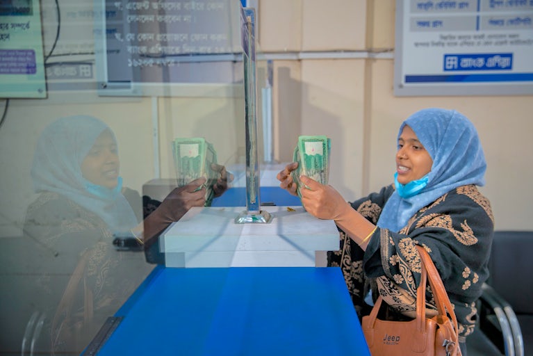 Woman in a headdress counting money.