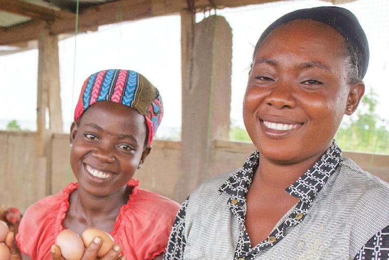 Two women holding eggs and smiling.
