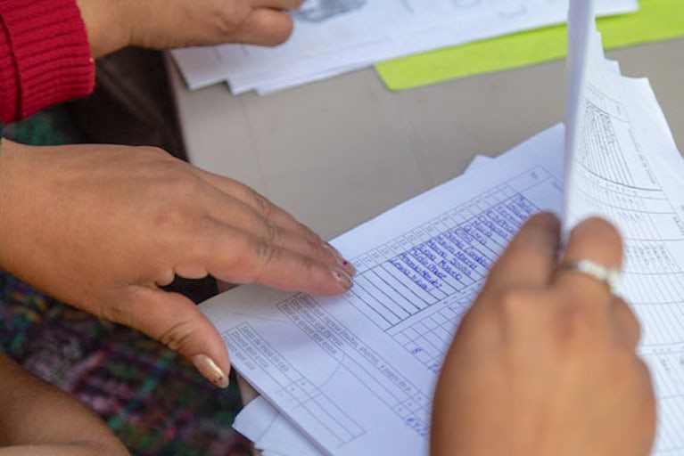Close up of a person's hands flipping through papers.