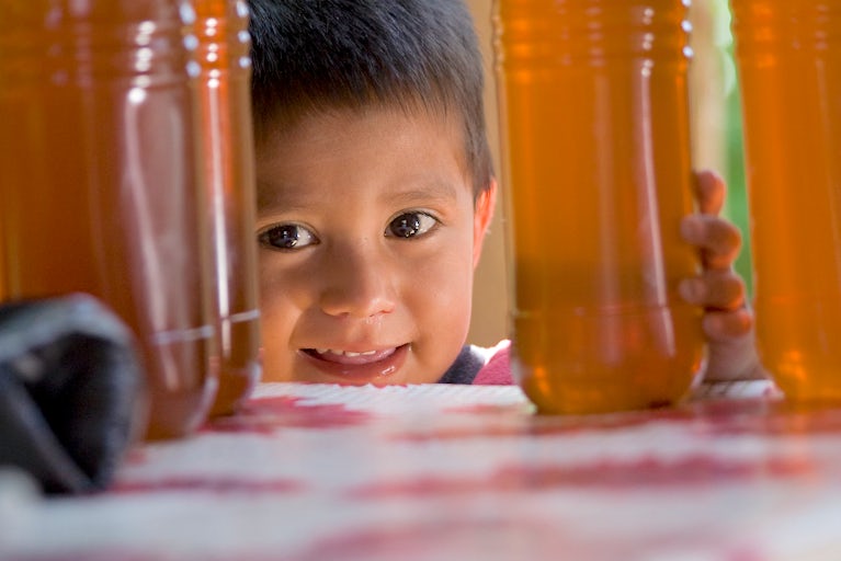 A kid is shown next to honey.