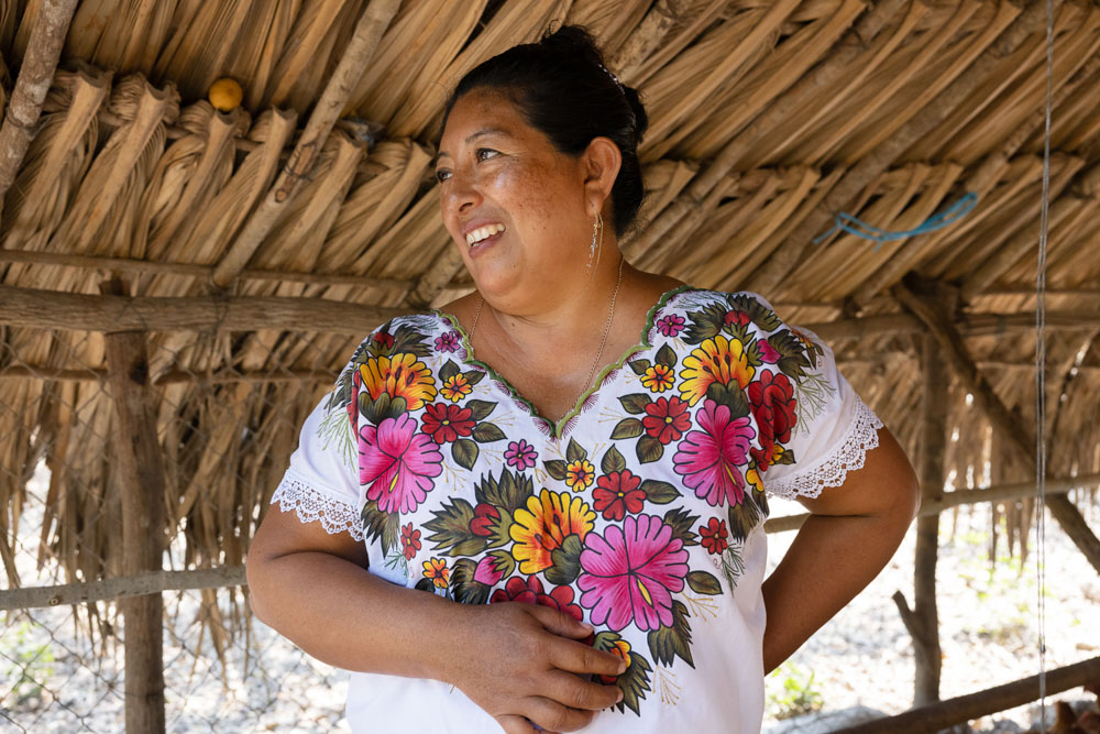 A Mexican woman smiling and looking to her right.