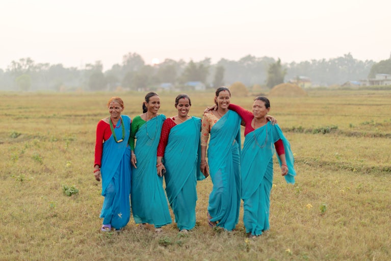 Hari Kaia Khadka, Durga Paudel, Rupa Khatri, Jasi Oli, and Gahani Khadka (members of the Sagarmatha Co-op) walk together in the sunset at the Banke Goat Collection Center in Banke, Nepal.