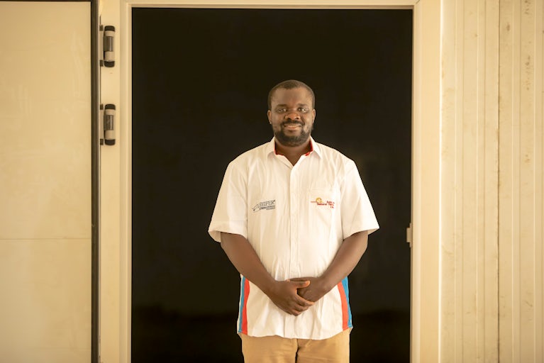 Man standing in an open doorway with his hands crossed over in front of him.