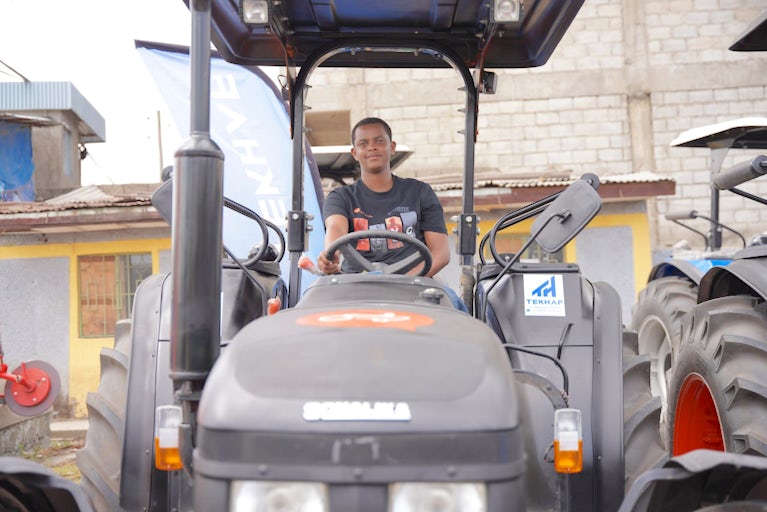 A man sits in the driver’s seat of a tractor.