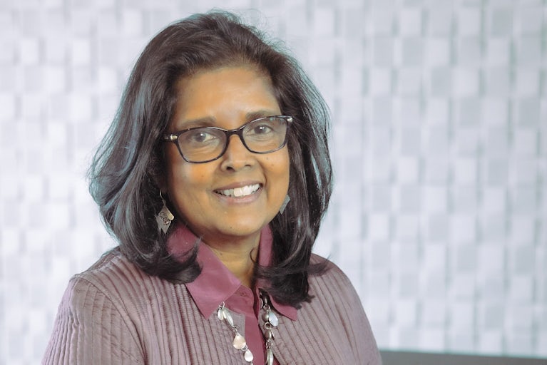 Surita Sandosham, president and CEO of Heifer International, stands with her hands clasped.