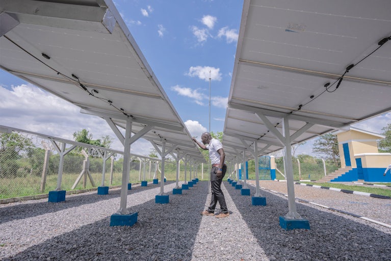 Kennedy Okuu, Heifer Project Coordinator W4DB, inspecting the solar system installed in Mauge village, Lyankonge parish, Dwaniro Subcounty.