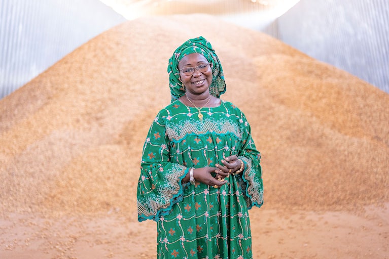 Black woman standing in green dress smiling.