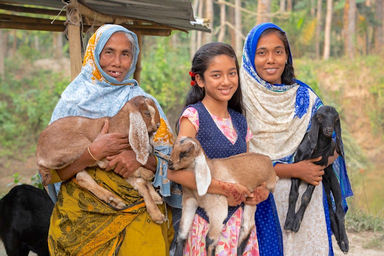 Women holding goats.